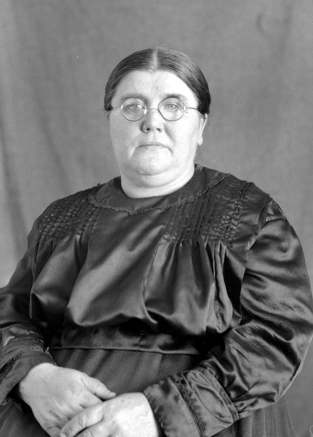 Portrait de studio en buste dans un décor dépouillé de Marie Pelletier âgée d'environ 55 ans.