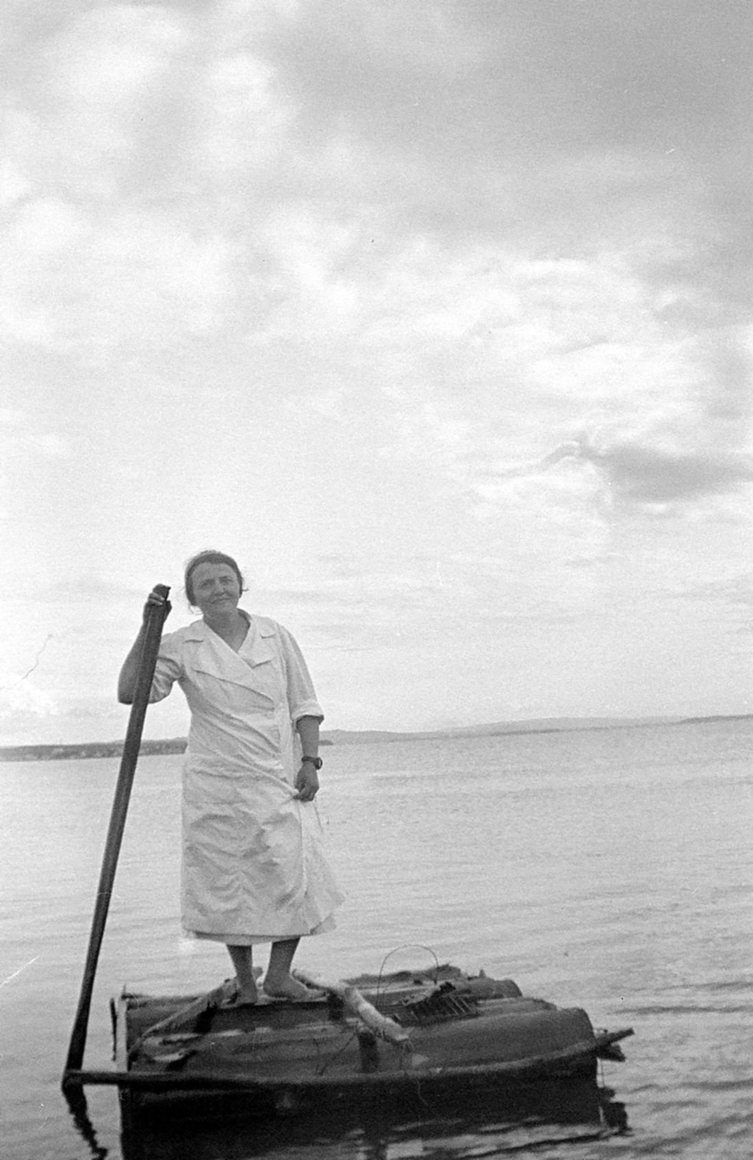 Marie-Alice Dumont en maillot de bain debout sur un radeau rudimentaire.