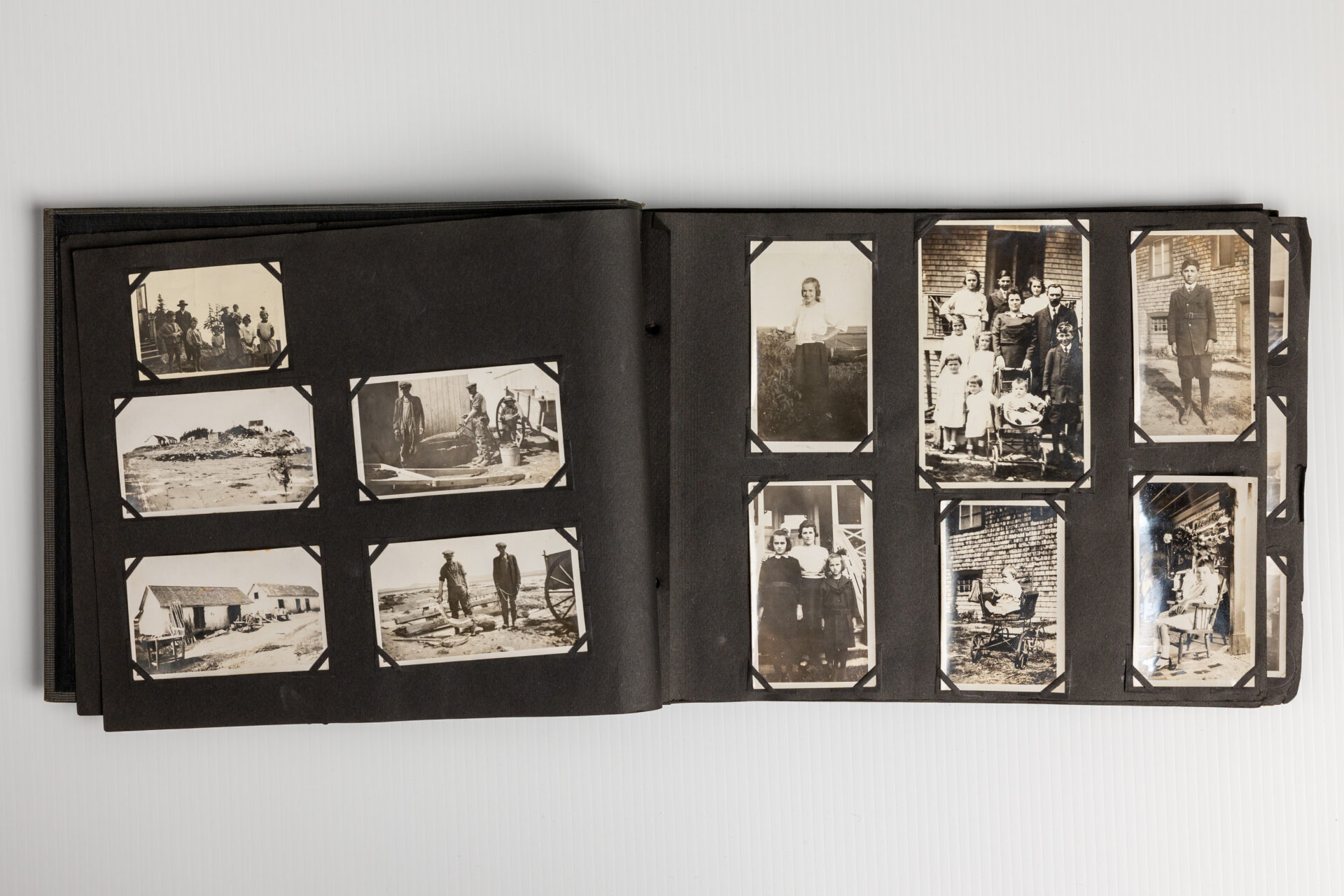 Deux pages d'un album contenant onze photographies de membres de la famille Dumont pris en plein air ou devant une maison.