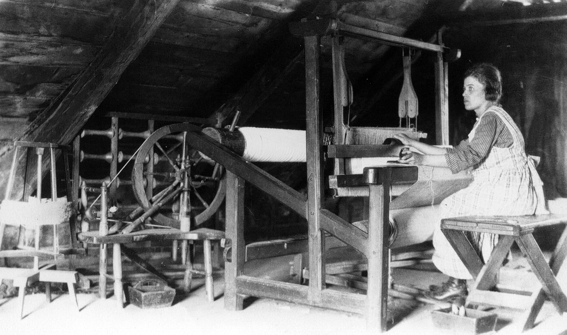 Marie-Louise Dumont travaillant au métier à tisser dans un grenier.