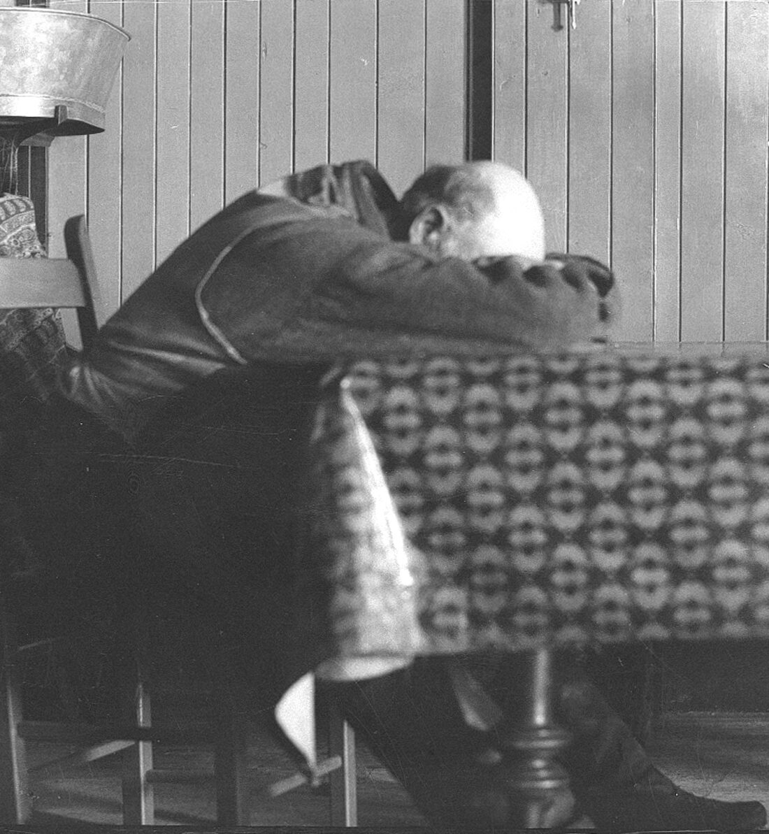 Uldéric Dumont endormi la tête entre les bras reposés sur la table de cuisine.