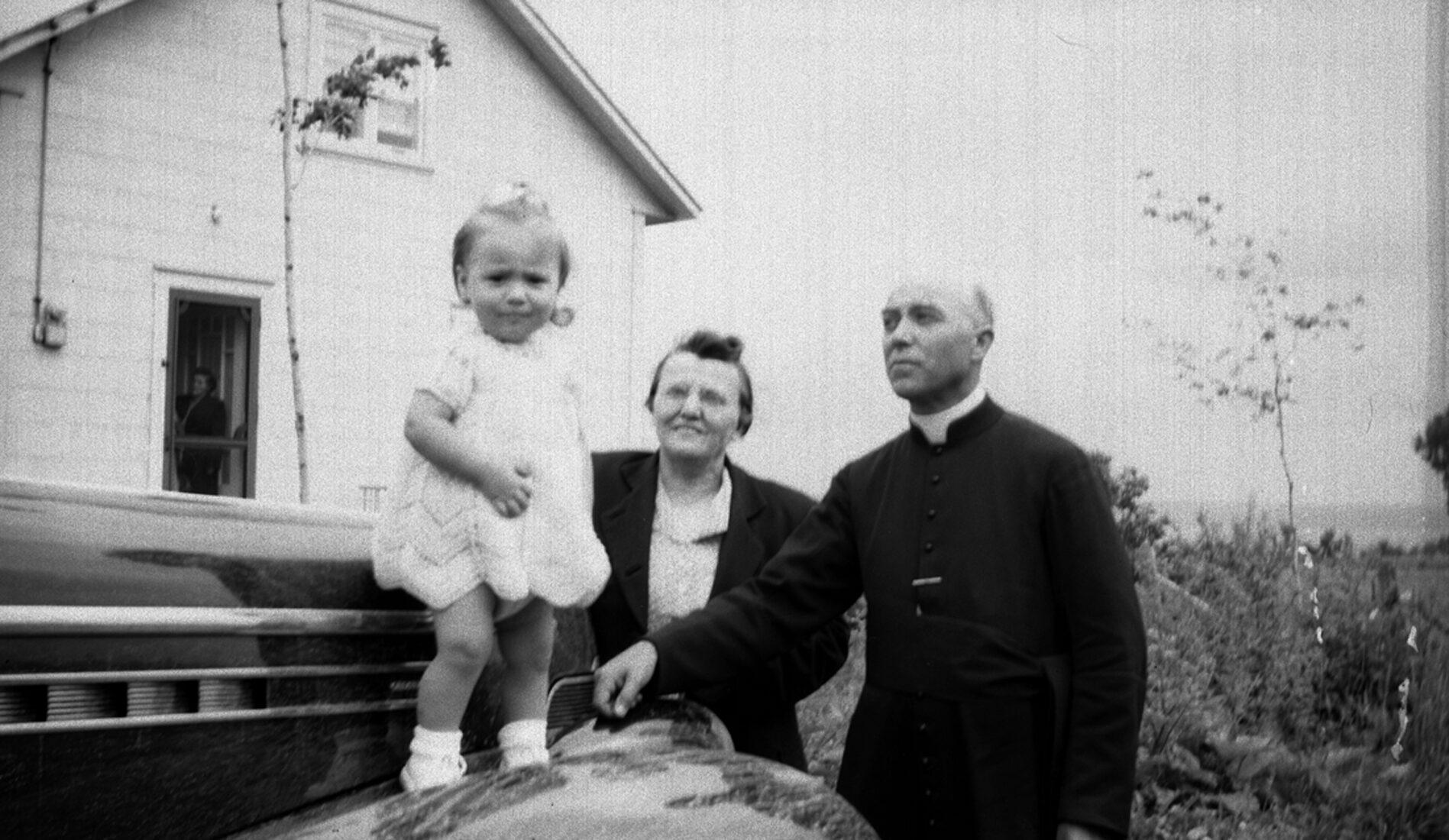 Marie-Alice Dumont et son frère Joseph-Napoléon posant près d'une voiture en compagnie de leur filleule Céline âgée d'environ 2 ans.