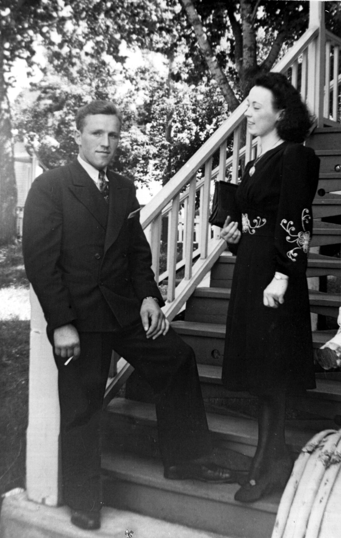 Rosalie et Camille élégamment vêtus et debout dans les escaliers sur le côté de la maison de Marie-Alice Dumont.