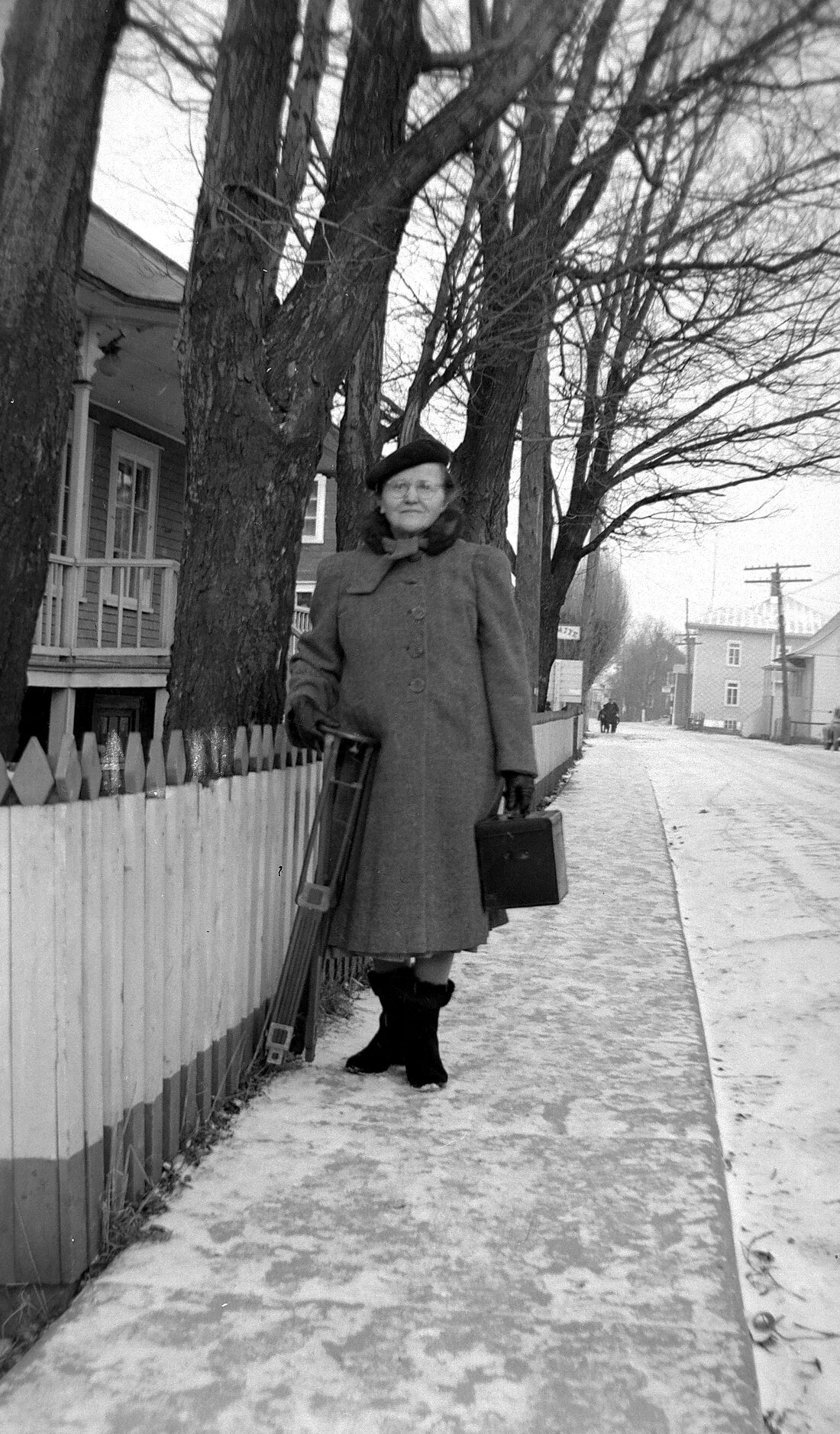 Marie-Alice Dumont âgée d'environ 60 ans posant avec sa caméra à l'extérieur, devant chez elle, en hiver.