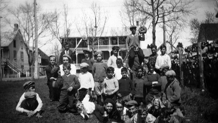 Une trentaine de jeunes garçons posés à l'extérieur, certains grimacent, d'autres prennent une pose rigolote, d'autres sérieuse.