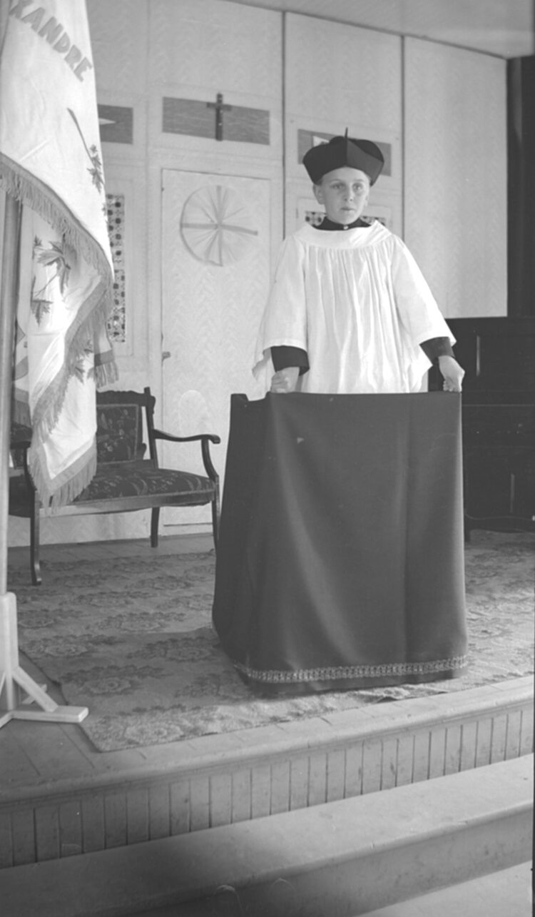 Un jeune servant de messe (ou enfant de choeur) sur l'estrade d'une église.