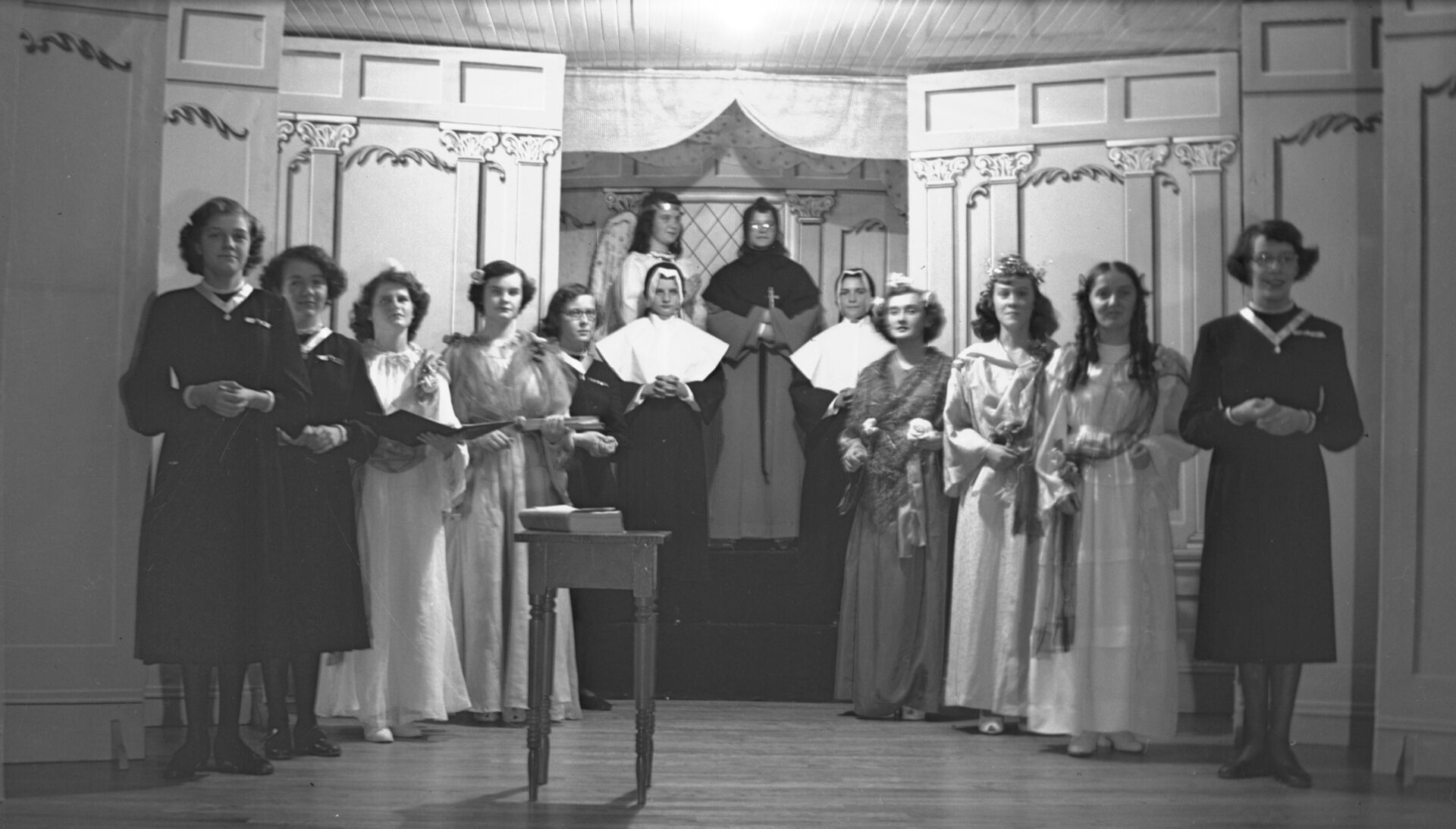 Portrait d'une troupe de théâtre posant sur la scène et composée de couventines.