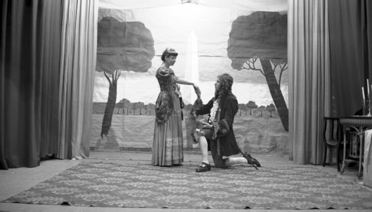 Une comédienne et un comédien costumés sur une scène.