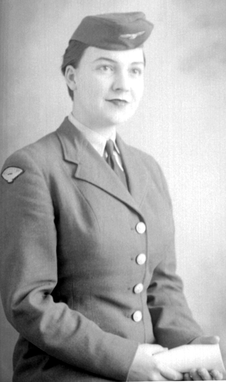 Portrait de studio d'une jeune femme en uniforme d'hôtesse de l'air dans un décor dépouillé.