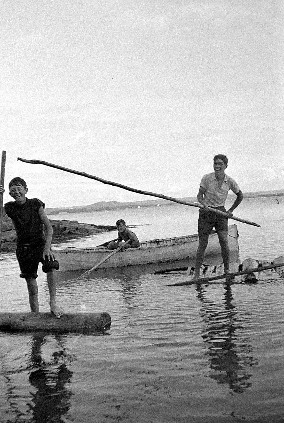 Trois jeunes garçons en baignade dans le fleuve Saint-Laurent et se taquinant.