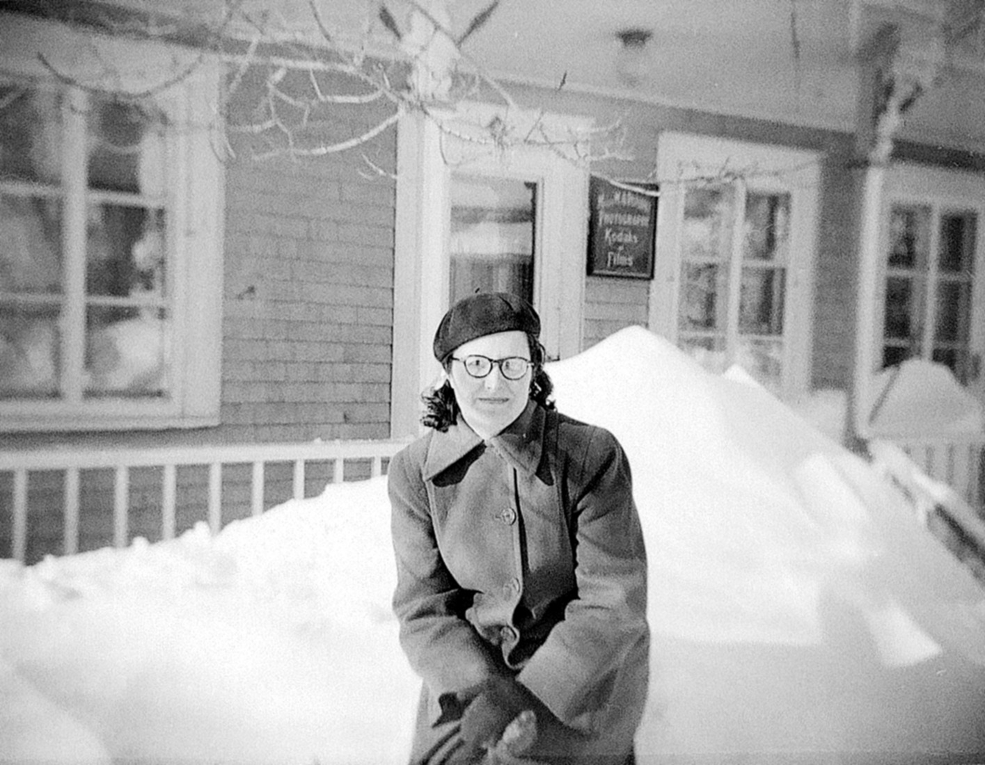 Une femme posant devant le studio Dumont assise dans un banc de neige.