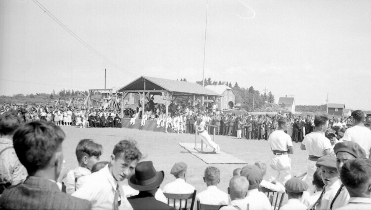 Une foule en plein air observant les prouesses d'un acrobate.