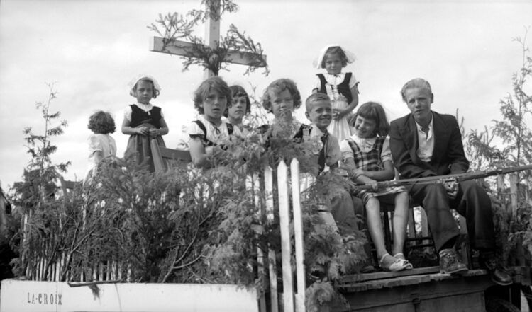 Neuf jeunes filles et garçons sur un char allégorique intitulé "La Croix".