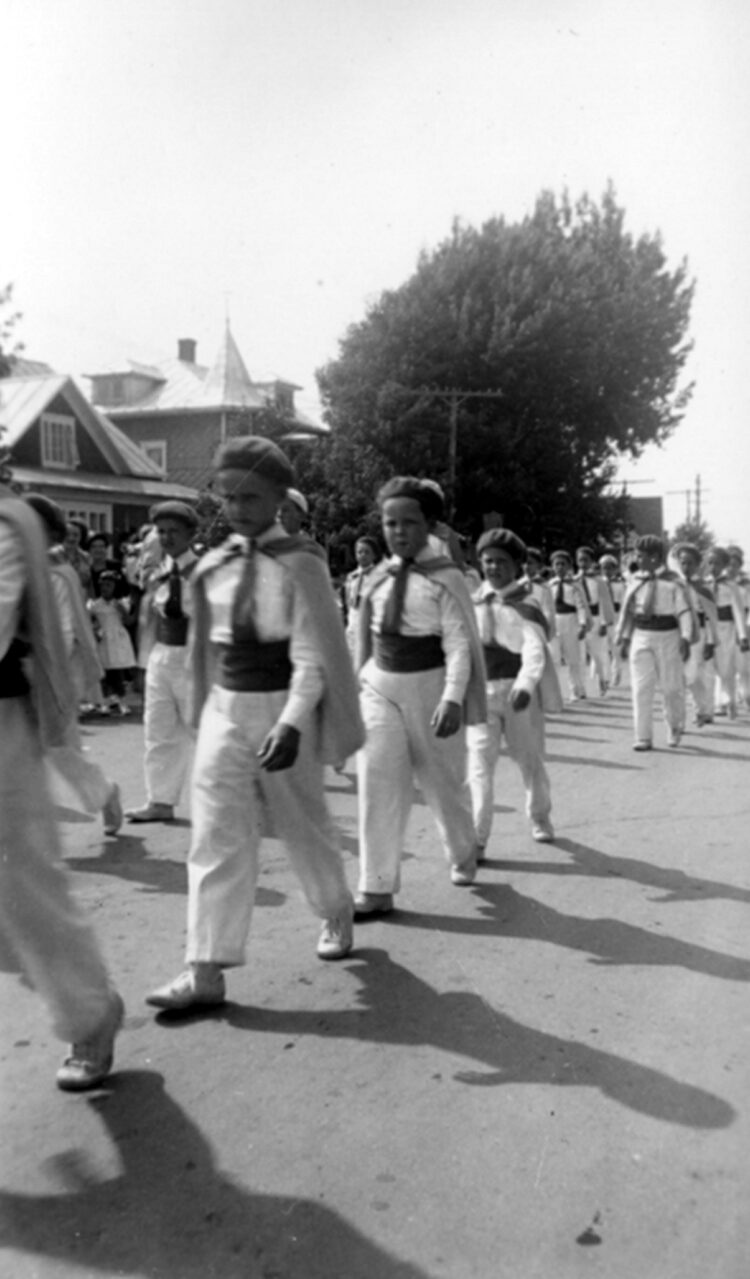Parade de jeunes garçons et filles en uniforme.