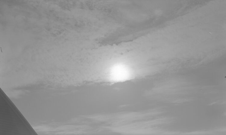 Éclipse solaire dans un ciel partiellement nuageux.