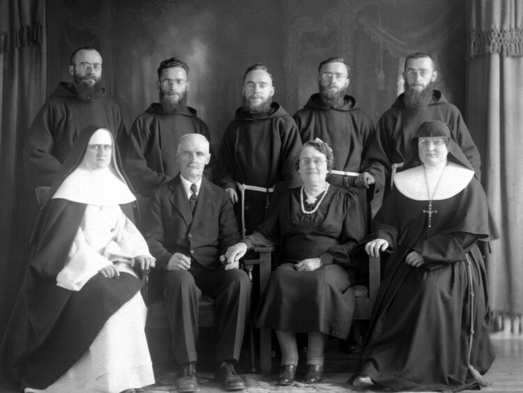 Portrait de studio d'une famille comprenant les deux parents et leurs sept enfants, tous d'âge adulte et en habits de religieux ou de religieuses.