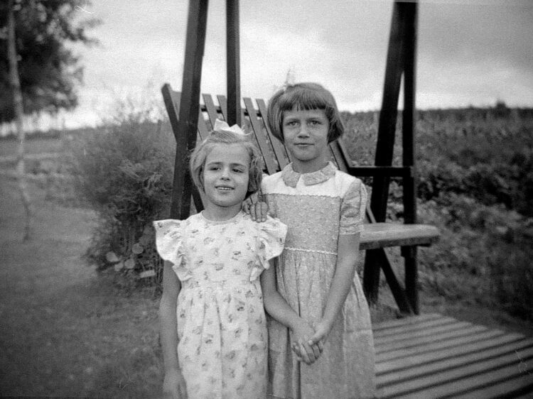 Deux jeunes filles à l'extérieur devant une balançoire.