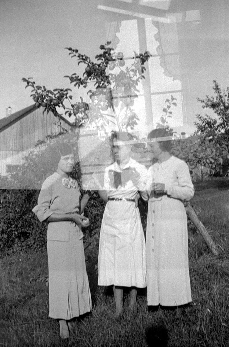 Trois jeunes femmes dans un verger et, due à une double exposition du négatif, une fenêtre superposée à cette scène.