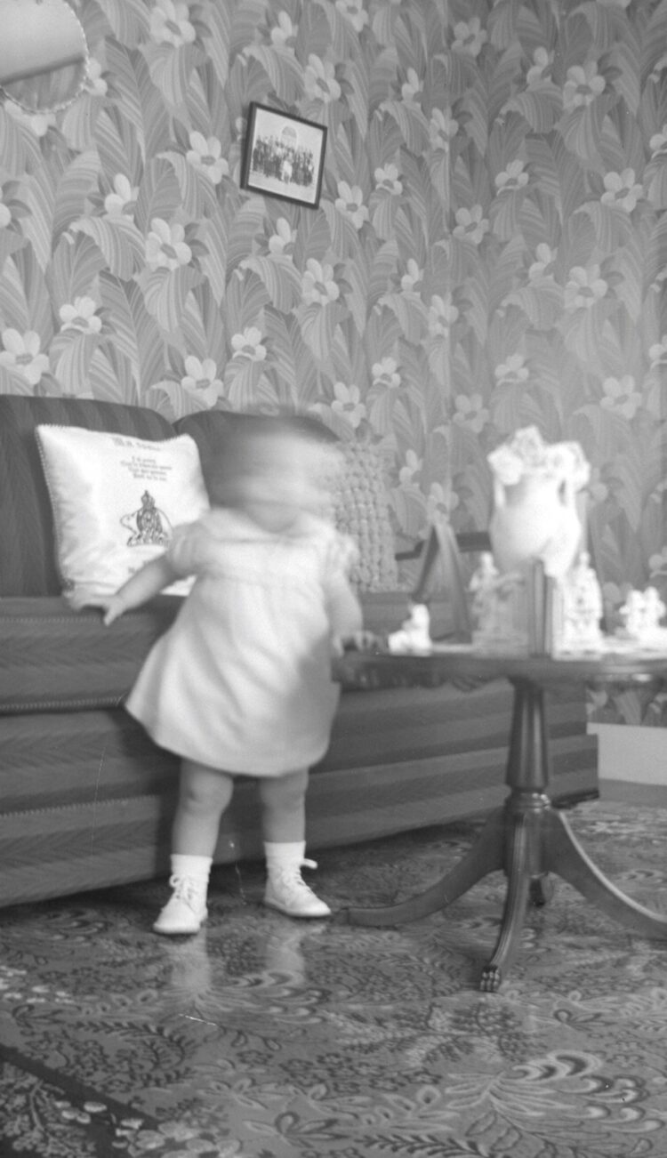 Une fillette d'environ deux ans dans un environnement domestique et au visage floue.