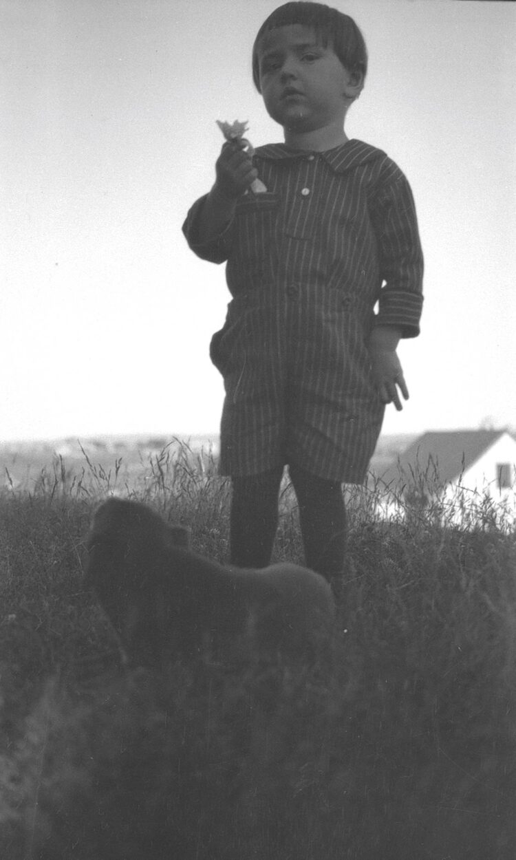 Contre-plongée sur Origène Dumont âgé d'environ trois ans, à l'extérieur.