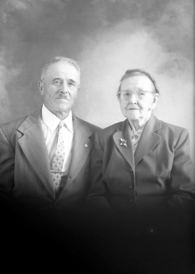 Portrait de studio de François Dumont et de Mary April dans un décor dépouillé.