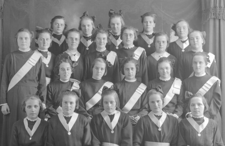 Portrait de studio de 22 jeunes filles en uniforme de couventine.