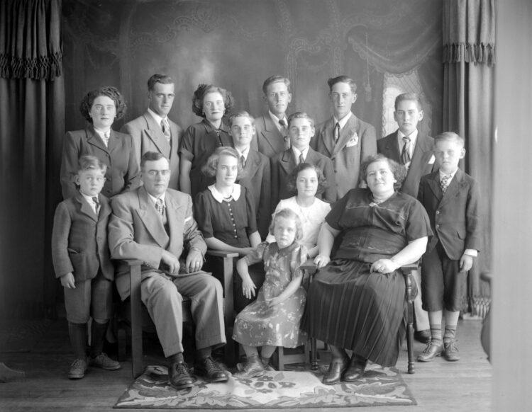 Portrait de studio d'une famille comprenant les deux parents et leurs 13 enfants.