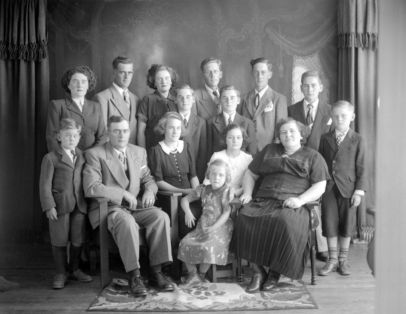 Portrait de studio d'une famille comprenant les deux parents et leurs 13 enfants.