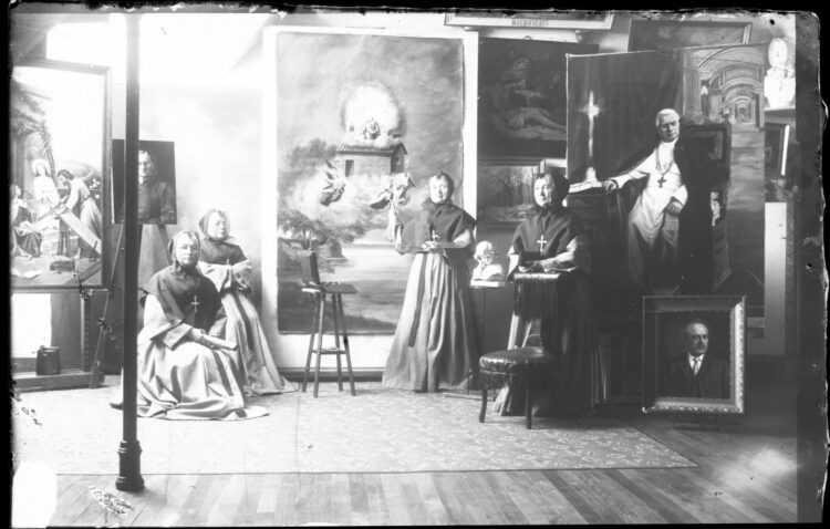Elmina Lefebvre et trois autres Soeurs entourées de grandes toiles au milieu de l'atelier de peinture des Soeurs de la Charité de Québec.