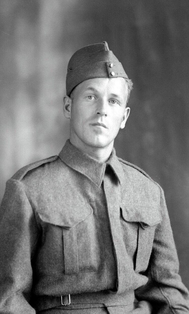 Portrait en buste d'un jeune homme en habits de militaire dans un décor dépouillé.
