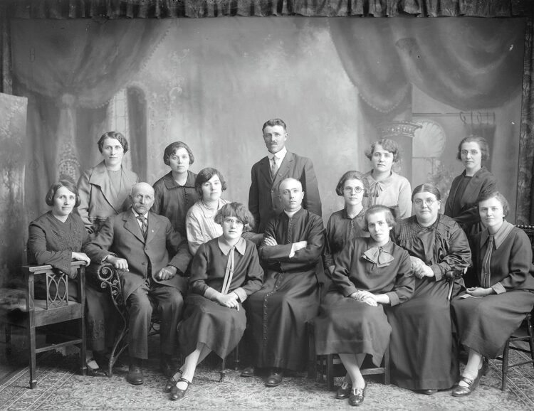 Portrait des 14 membres de la famille Dumont dans le studio d'Ulric Lavoie.
